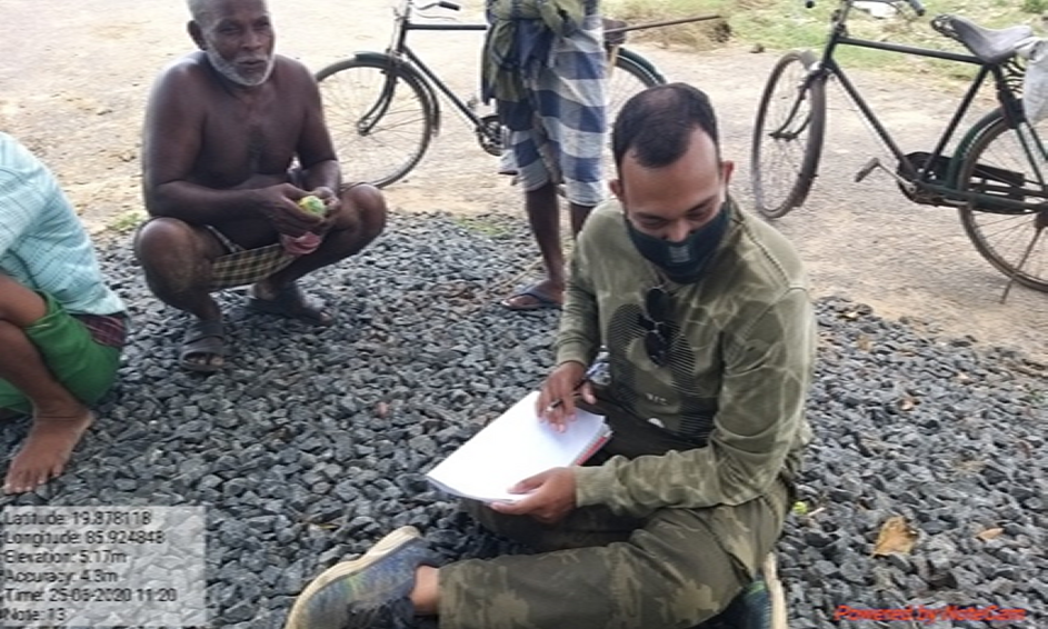 notes, talking to a number of fishermen.  There are bicycles in the background. 